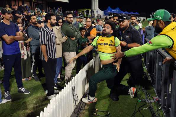Khushdil Shah being held back by the police during the altercation 
