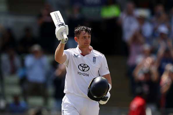Jamie Smith raises his bat after reaching his 100 
